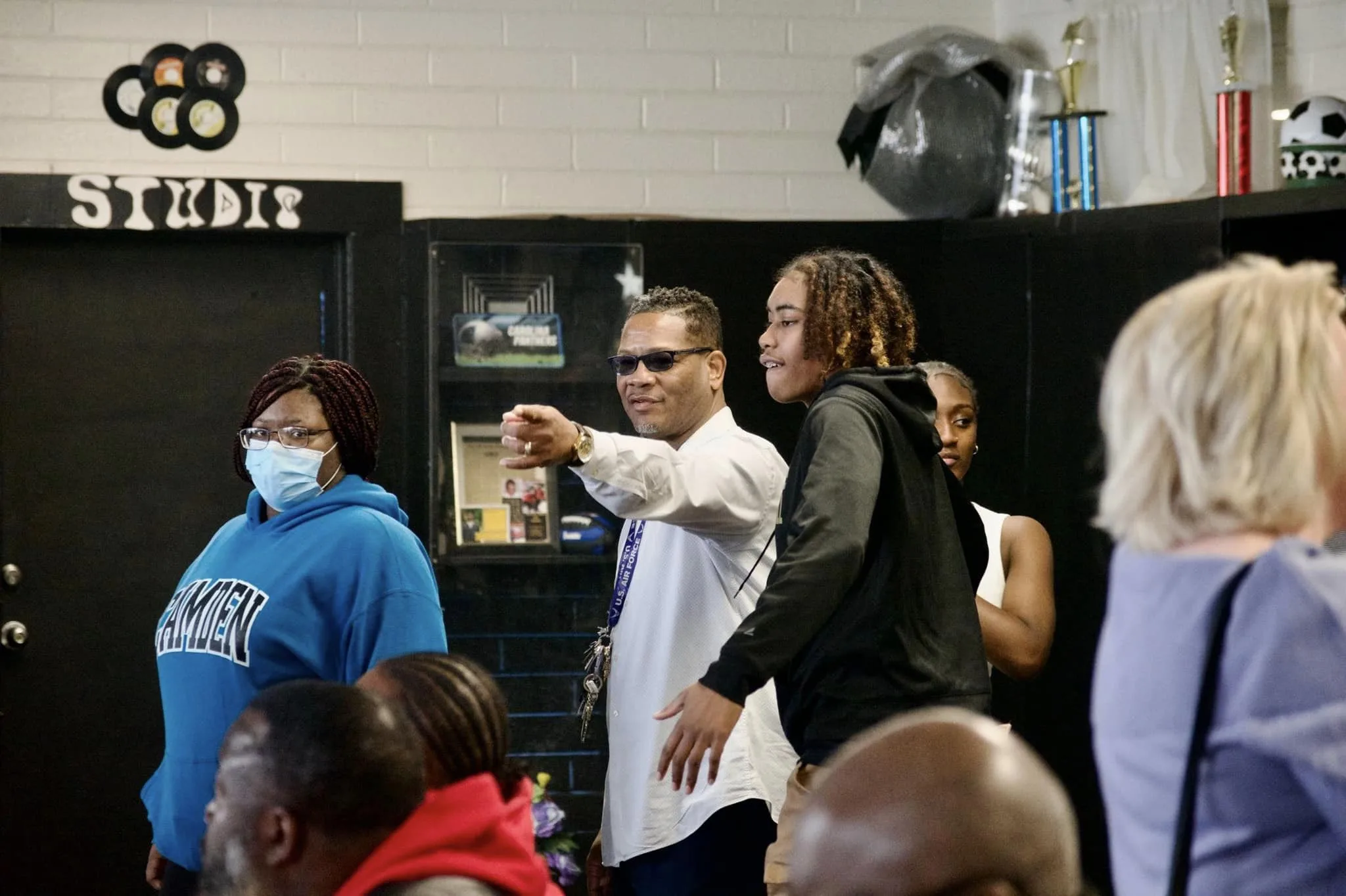 MIAC Brian Mayes is pointing while surrounded by volunteers and students in the program.